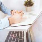 person writing on laptop